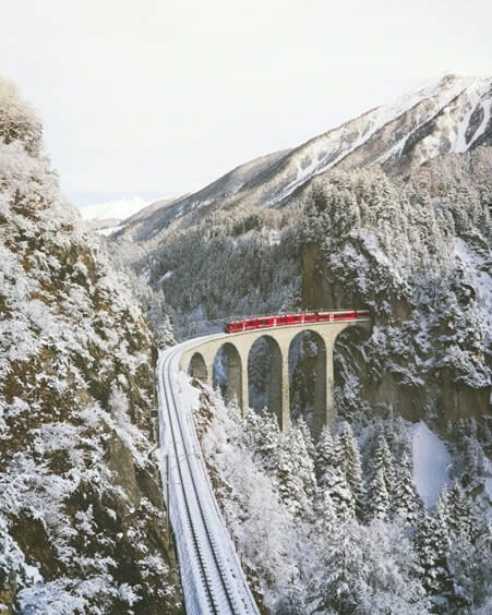 red train across mountains