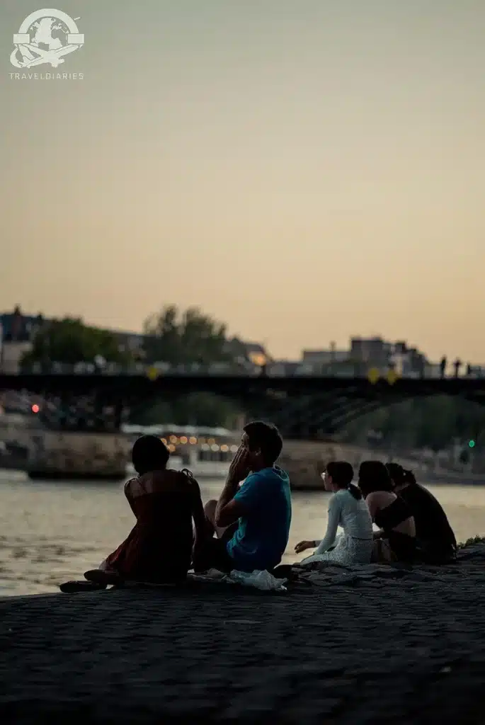 people sitting on a rock by a body of water; Paris, France