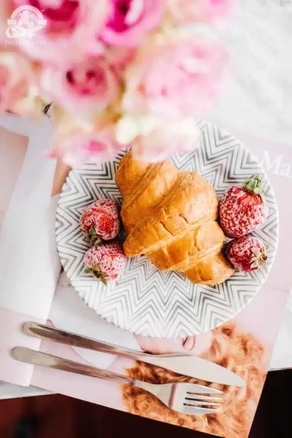 croissant and strawberries on a plate; Paris, France
