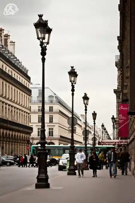 people walking on a street with tall buildings; Paris