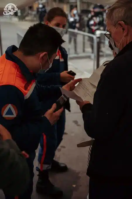 man in orange jacket holding paper; Paris