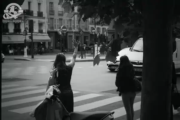 2. A women waving at a crosswalk; Paris, France